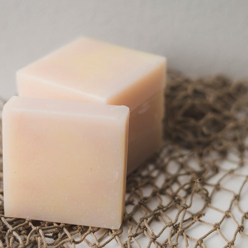 close up of 2 square, pink soap bars